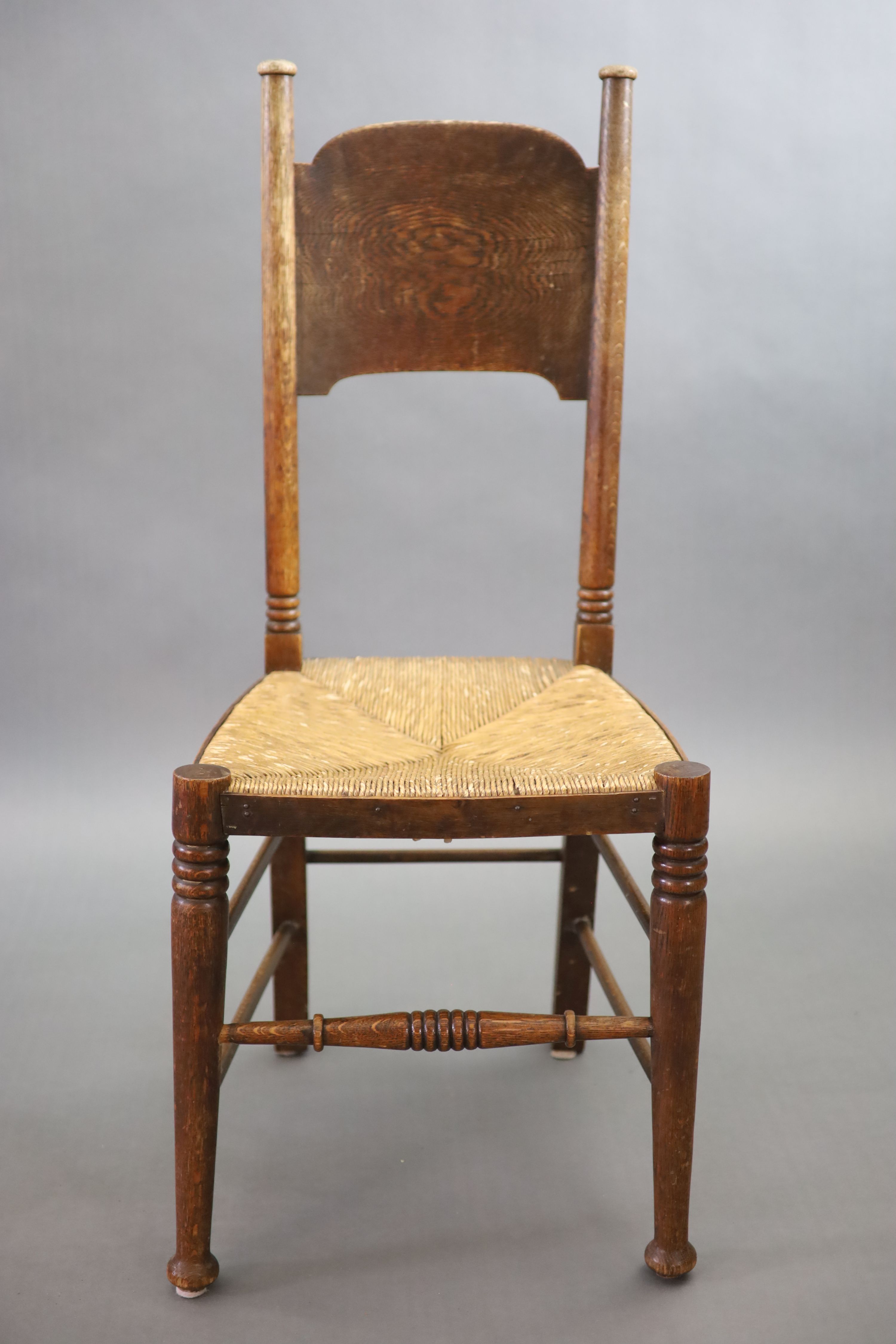 A set of six Arts & Crafts oak chairs, including a pair of carvers, in the Glasgow School manner by William Birch, High Wycombe, carvers W.58cm D.54cm H.109cm